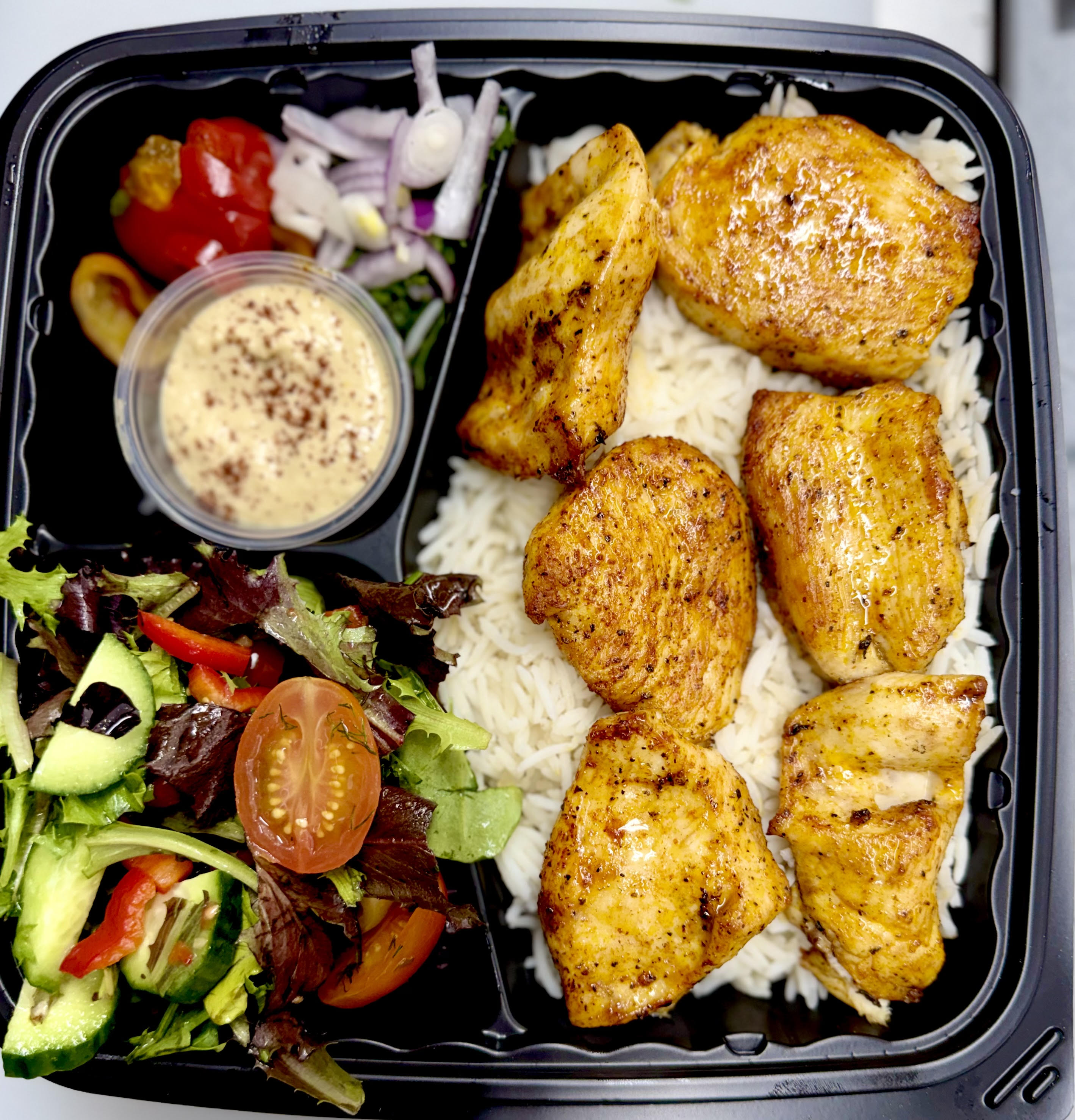 Fresh prep. Herbs, veggies, rice and meat — ready to eat.